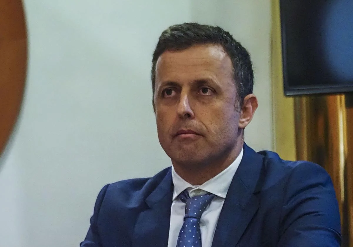 Retrato de Álvaro García Ortiz con traje azul y corbata azul con lunares blancos.