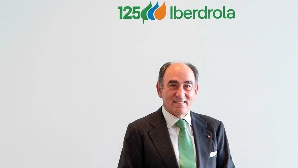 Retrato de Ignacio Sánchez Galán, presidente de Iberdrola, con traje oscuro, camisa blanca y corbata verde, ante un fondo blanco con el logotipo de la compañía.
