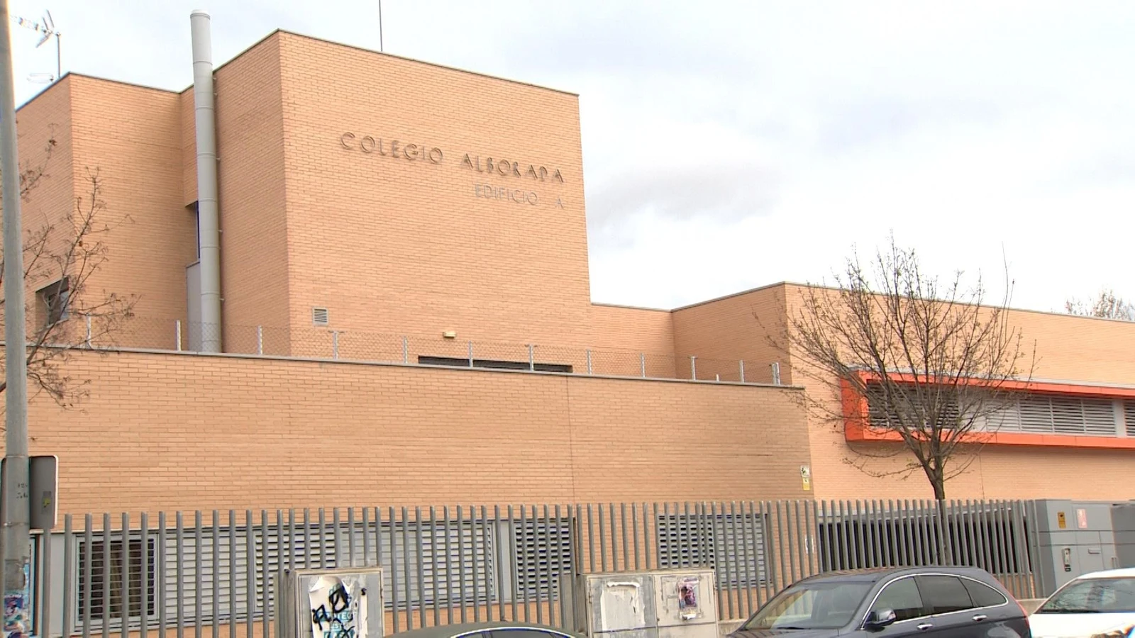 Fachada principal del Colegio Alborada en Alcalá de Henares, con muro de ladrillo y verja metálica.
