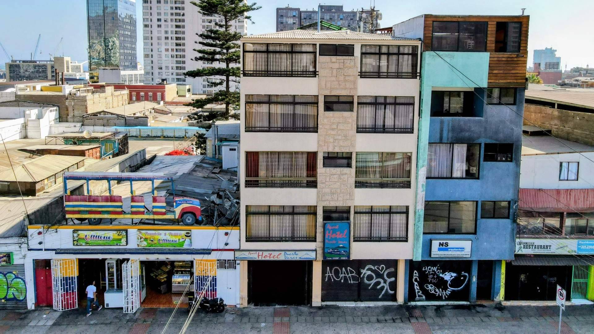 Fotografía aérea frontal de la fachada de un hotel céntrico en Antofagasta, mostrando su arquitectura y edificios colindantes en la calle principal.