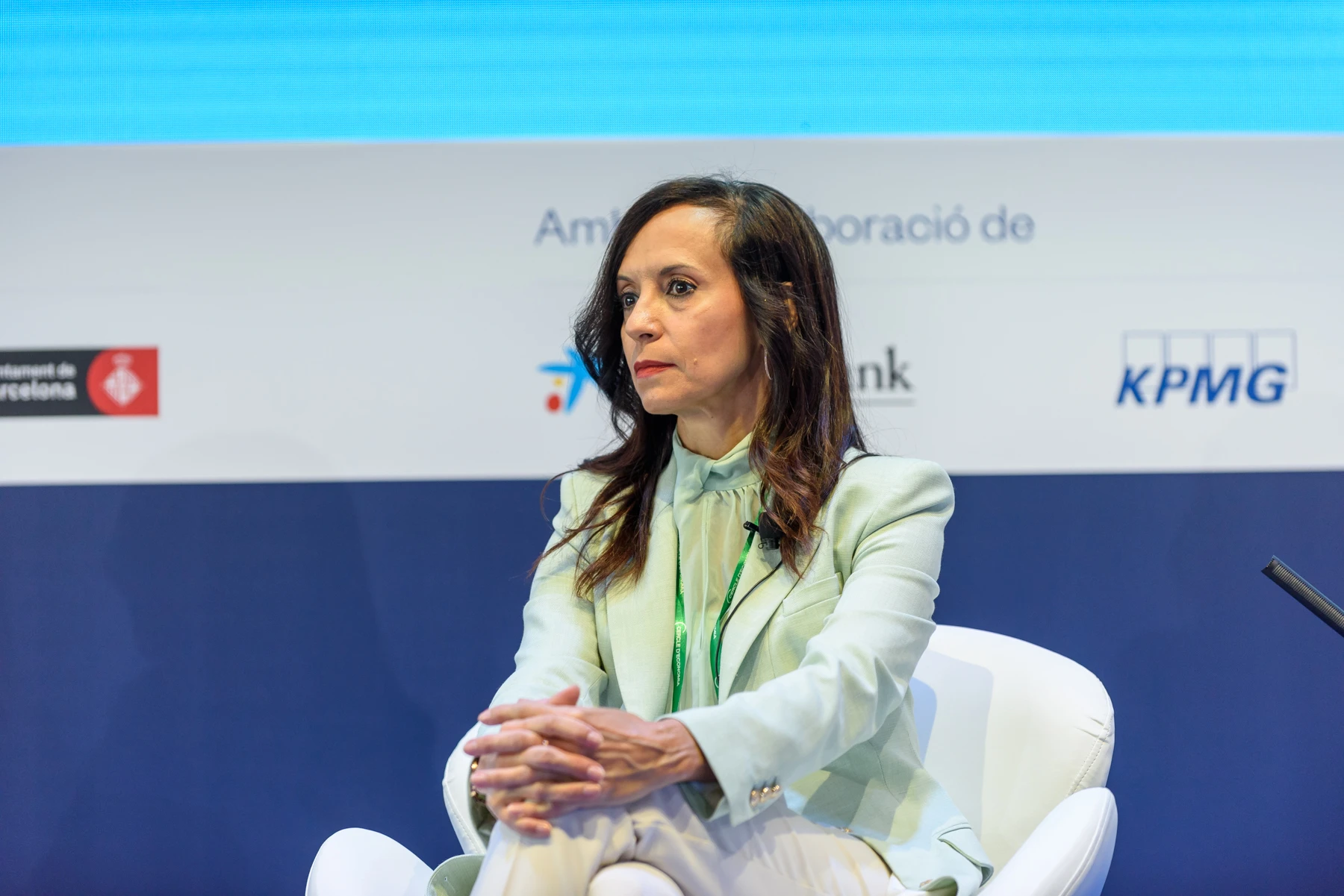 Fotografía editorial de Beatriz Corredor, presidenta de Redeia, sentada en un sillón blanco durante una conferencia corporativa.