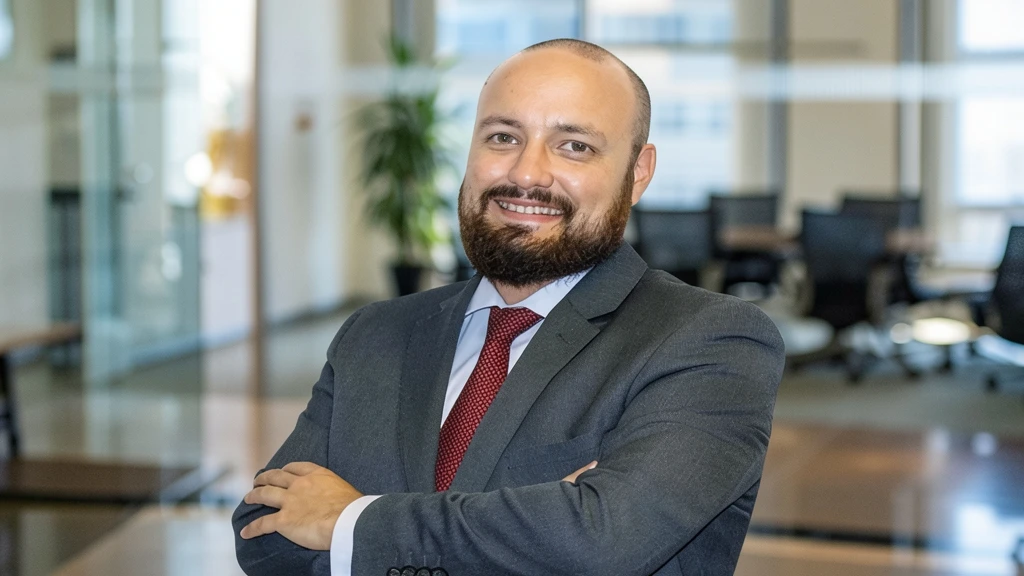 Fotografía editorial de Raúl Florido, abogado especialista en protección de datos y nuevas tecnologías, con traje y corbata roja, sonriendo con los brazos cruzados en una oficina.