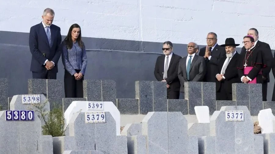 Fotografía editorial de los reyes Felipe VI y Letizia junto a representantes religiosos y autoridades frente a lápidas en un cementerio durante su visita oficial a Ceuta.
